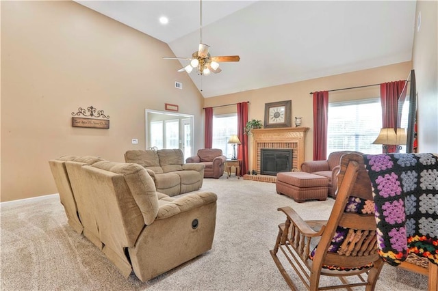 carpeted living room with ceiling fan, a fireplace, and high vaulted ceiling