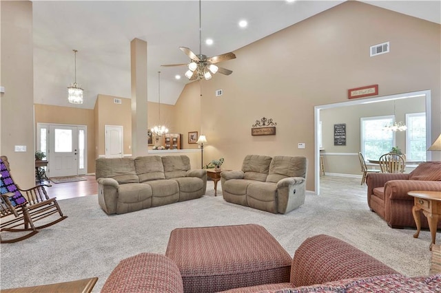 living room featuring ceiling fan with notable chandelier, high vaulted ceiling, and carpet floors