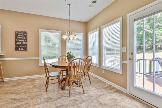 dining room with an inviting chandelier and plenty of natural light