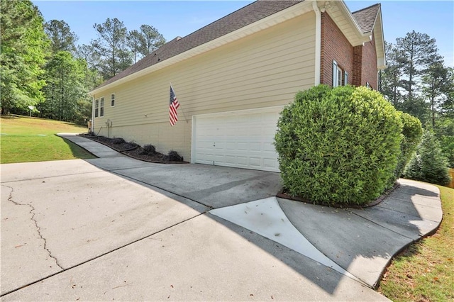 view of home's exterior featuring a garage and a lawn