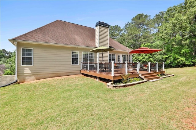 rear view of house featuring a yard and a deck