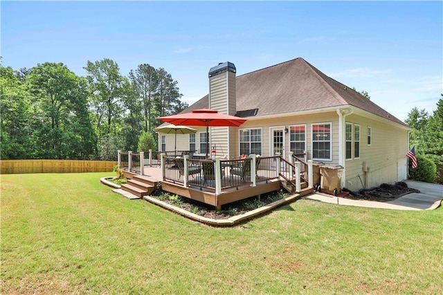 back of property with a wooden deck and a lawn