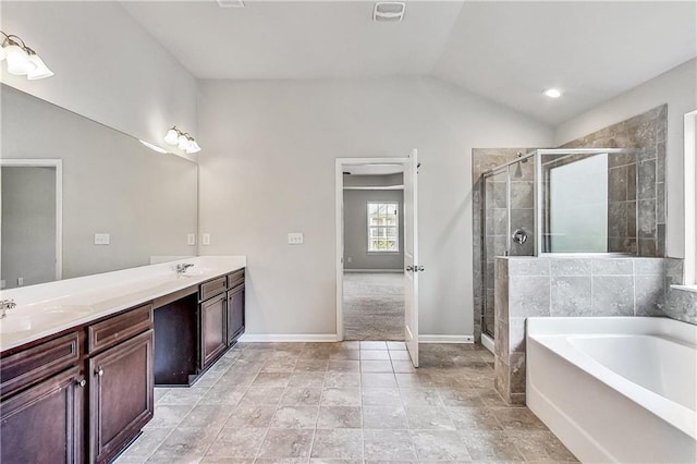 bathroom with vanity, vaulted ceiling, and plus walk in shower