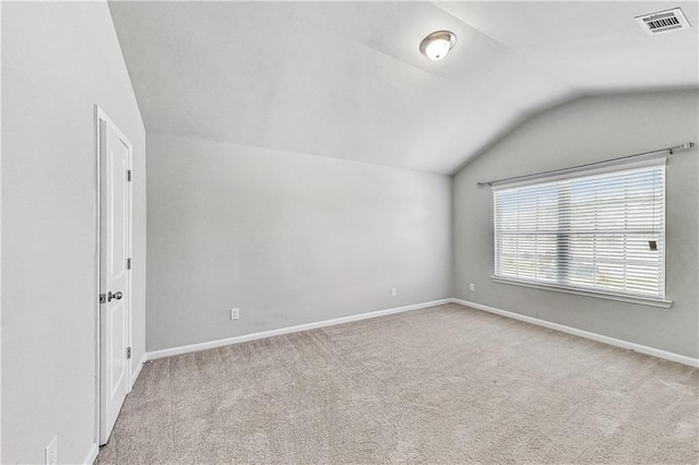 carpeted spare room with lofted ceiling