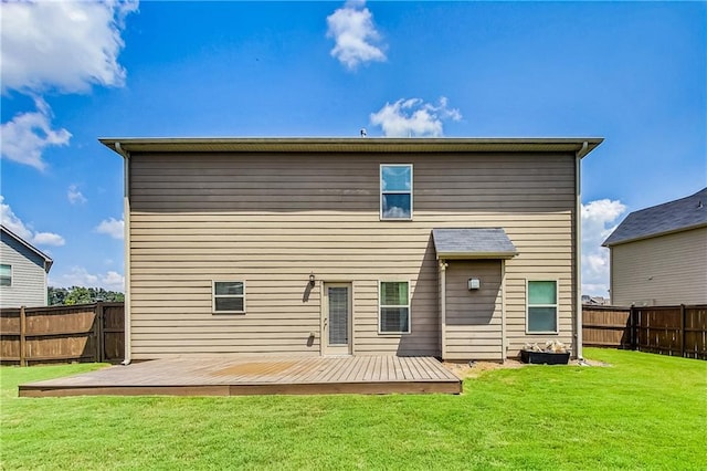 back of house with a deck and a lawn