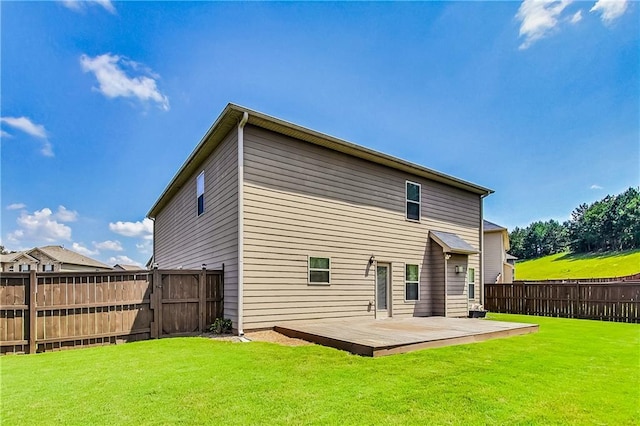 rear view of property with a wooden deck and a yard