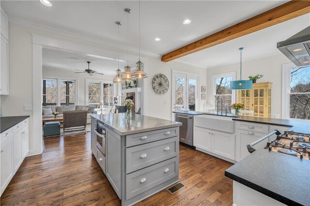 kitchen with a kitchen island, visible vents, a sink, open floor plan, and stainless steel appliances