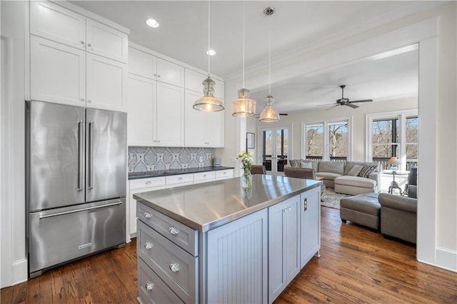 kitchen featuring decorative backsplash, a kitchen island, a ceiling fan, dark wood finished floors, and high quality fridge