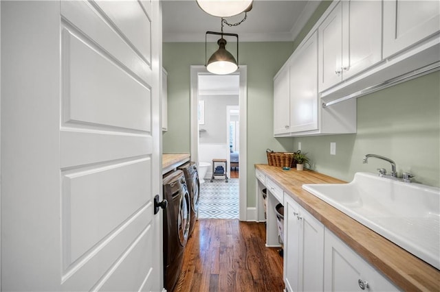 clothes washing area with baseboards, ornamental molding, dark wood-style flooring, and washing machine and clothes dryer