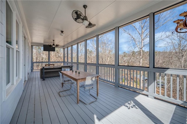 sunroom / solarium featuring a ceiling fan and outdoor dining area