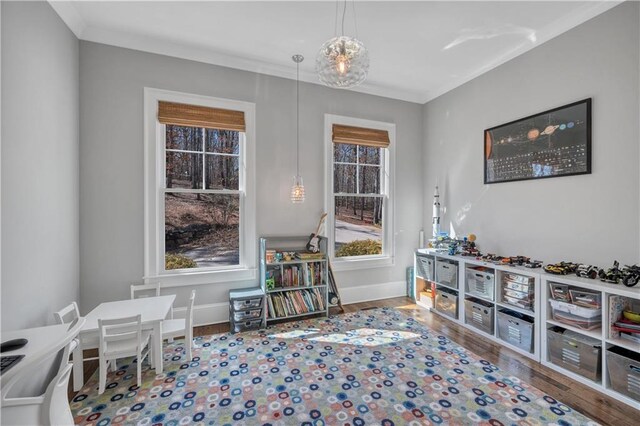 game room with crown molding, baseboards, and wood finished floors