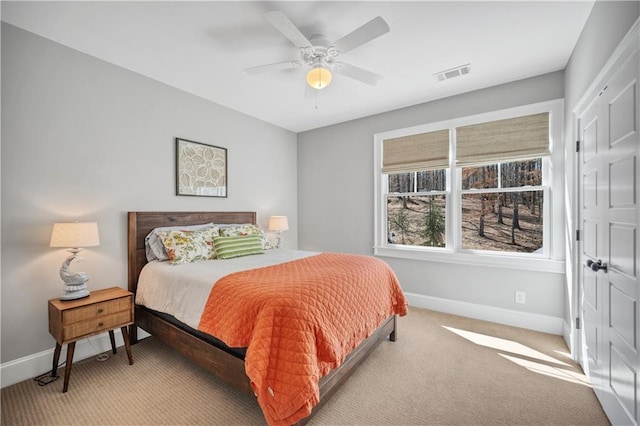 carpeted bedroom featuring baseboards, a ceiling fan, and visible vents