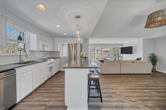 kitchen featuring a sink, dark wood-style flooring, appliances with stainless steel finishes, and a breakfast bar