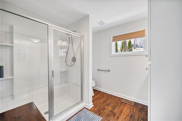full bath with visible vents, a stall shower, toilet, and wood finished floors