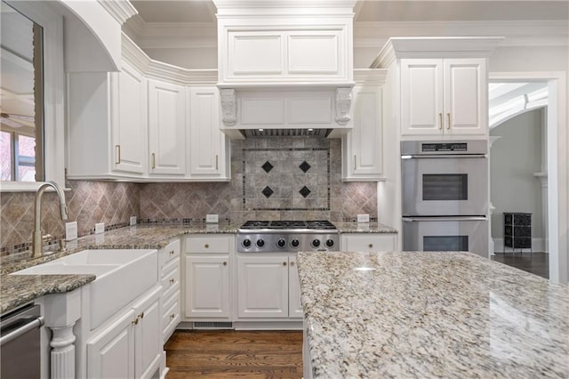 2260 Wood Falls Dr, Cumming, GA 30041 - kitchen with dark wood-style flooring, crown molding, appliances with stainless steel finishes, a sink, and white cabinetry