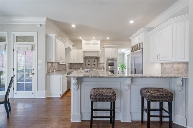 2260 Wood Falls Dr, Cumming, GA 30041 - kitchen with dark wood-style flooring, crown molding, appliances with stainless steel finishes, a sink, and white cabinetry