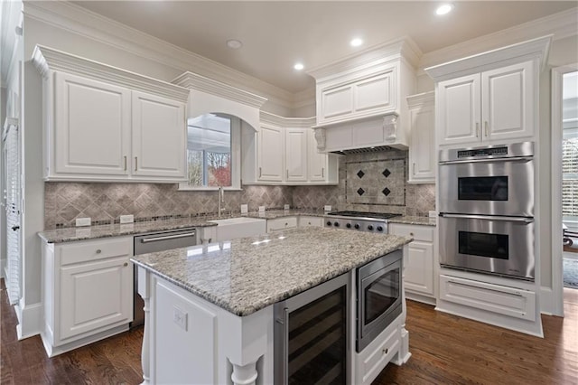 2260 Wood Falls Dr, Cumming, GA 30041 - kitchen featuring a kitchen breakfast bar, backsplash, appliances with stainless steel finishes, a peninsula, and white cabinetry