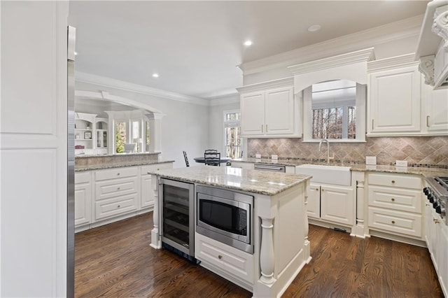 2260 Wood Falls Dr, Cumming, GA 30041 - kitchen featuring dark wood finished floors, a sink, stainless steel microwave, beverage cooler, and white cabinetry