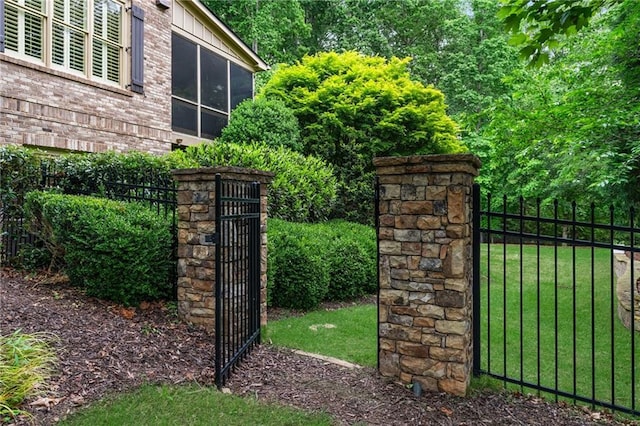 2260 Wood Falls Dr, Cumming, GA 30041 - view of gate featuring fence and a lawn