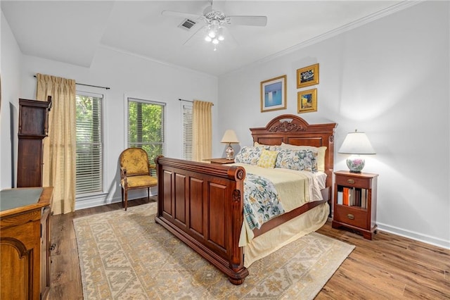 bedroom with light wood-type flooring, baseboards, ceiling fan, and crown molding
