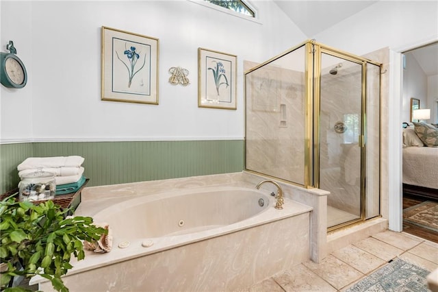 ensuite bathroom featuring a shower stall, a bath, a wainscoted wall, and tile patterned floors