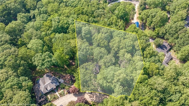 aerial view of property's location featuring a heavily wooded area and property parcel outlined