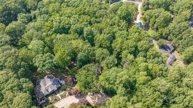aerial view of property and surrounding area with a heavily wooded area