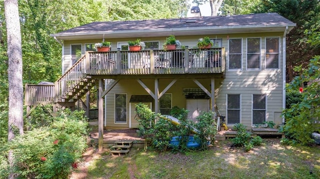 back of property featuring a wooden deck, a chimney, and stairs