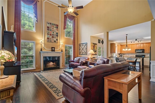 1360 Woodvine Way, Alpharetta, GA 30005 - living room featuring a high ceiling, a ceiling fan, a fireplace, dark wood-type flooring, and a chandelier