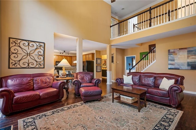 1360 Woodvine Way, Alpharetta, GA 30005 - living room with wood finished floors, a high ceiling, baseboards, and stairs