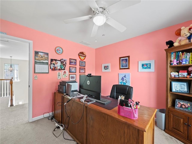 office space featuring light carpet, ceiling fan, visible vents, and baseboards