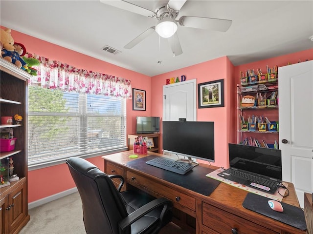 office area featuring a ceiling fan, visible vents, light carpet, and baseboards