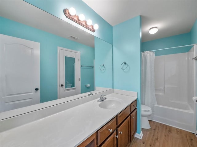 full bathroom with visible vents, toilet, wood finished floors, shower / bathtub combination with curtain, and vanity