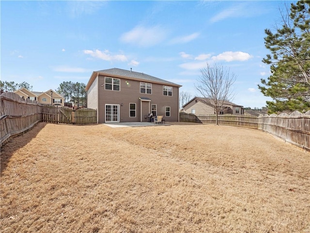 rear view of property featuring a patio area and a fenced backyard