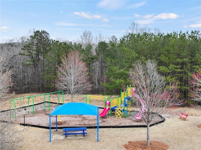 communal playground featuring a forest view