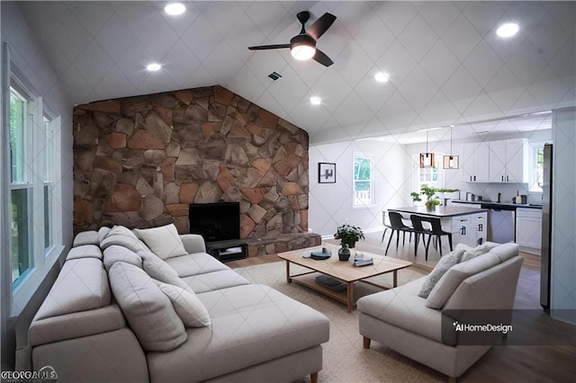 kitchen with appliances with stainless steel finishes, white cabinetry, wood-type flooring, and wall chimney exhaust hood