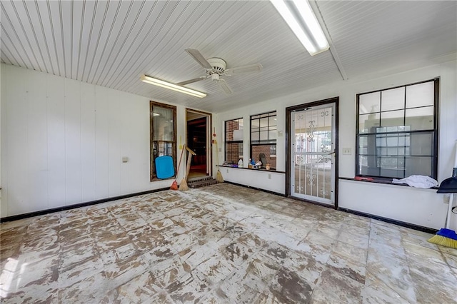 unfurnished sunroom with ceiling fan