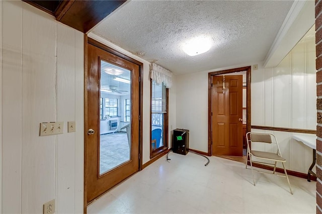 doorway to outside with a textured ceiling