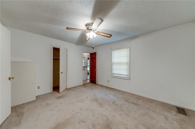 unfurnished bedroom featuring light colored carpet, a textured ceiling, and ceiling fan