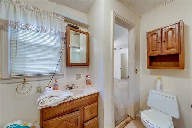 bathroom with ornamental molding, vanity, and toilet