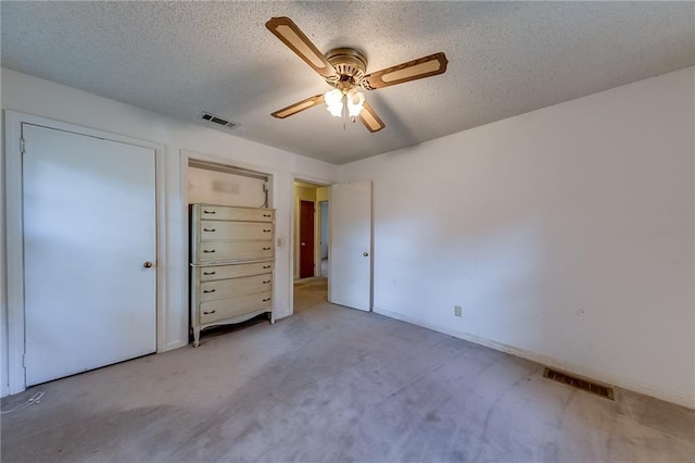 unfurnished bedroom with ceiling fan, a textured ceiling, and light carpet