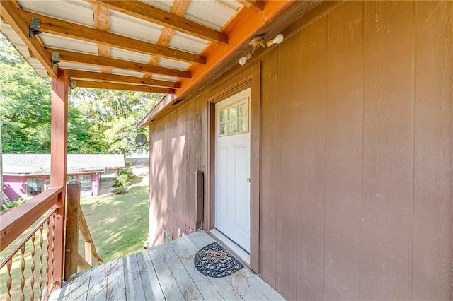 view of exterior entry featuring a yard and a wooden deck