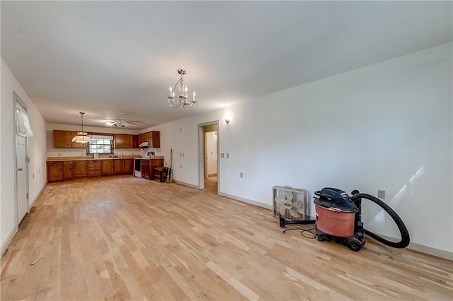 misc room with ceiling fan with notable chandelier and light wood-type flooring