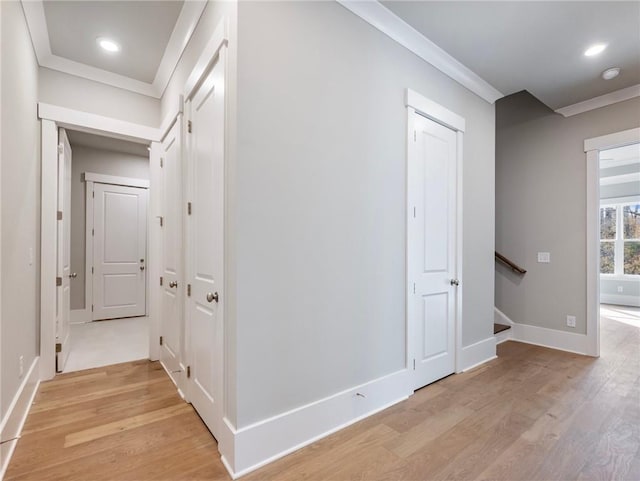 hall featuring ornamental molding and light hardwood / wood-style flooring