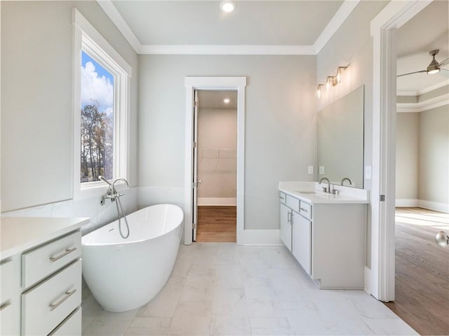 bathroom with vanity, ceiling fan, crown molding, hardwood / wood-style floors, and a bathing tub