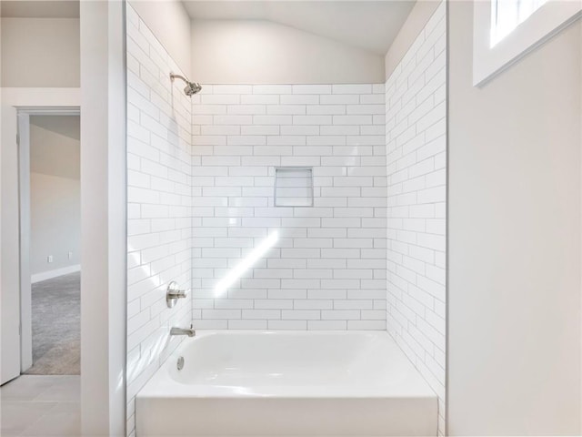 bathroom featuring tile patterned floors, tiled shower / bath combo, and lofted ceiling