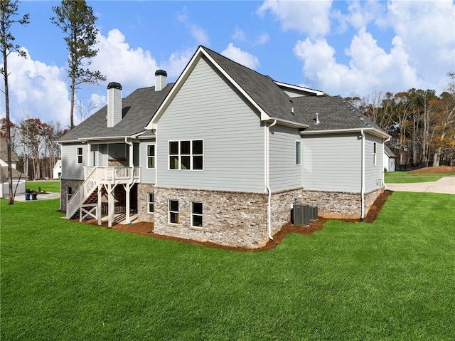 back of property featuring central AC and a yard