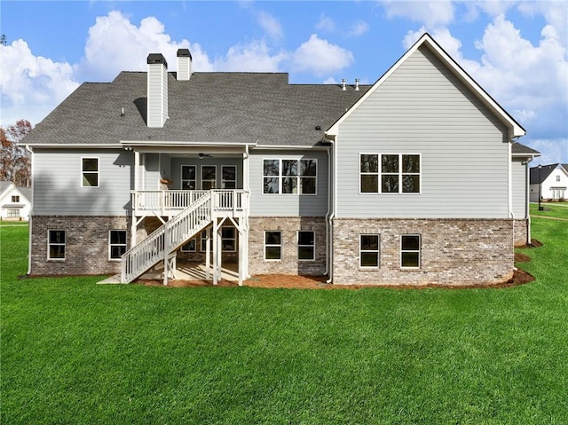 rear view of house featuring a yard and a wooden deck