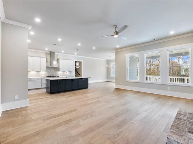 unfurnished living room with ceiling fan, ornamental molding, sink, and light hardwood / wood-style flooring