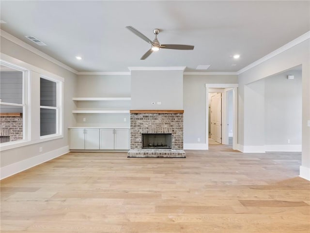 unfurnished living room featuring ceiling fan, crown molding, light hardwood / wood-style flooring, and a brick fireplace